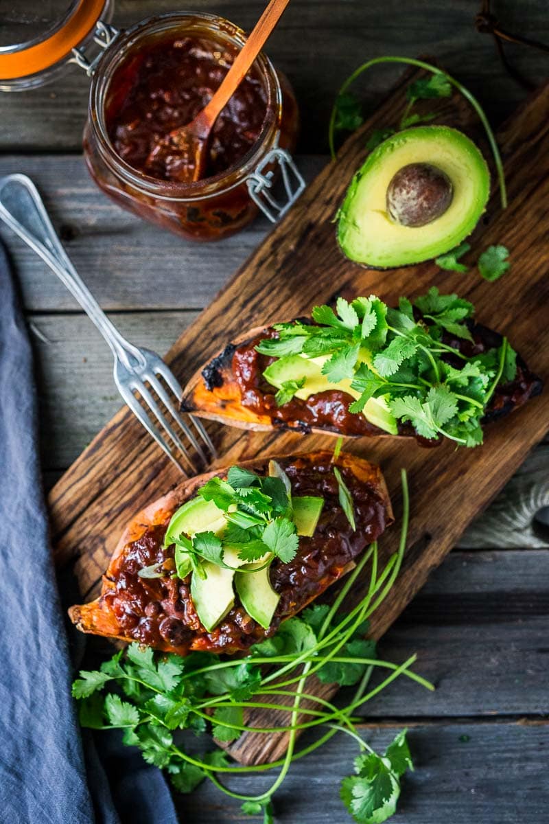 These Black Bean Stuffed Sweet Potatoes are incredibly delicious! Made with BBQ sauce, black beans  (optional chicken) melty cheese, avocado and cilantro -perfect for mixed households who have meat-lovers, vegetarians, and vegans, all living under the same roof. Vegan-adaptable and gluten-free.