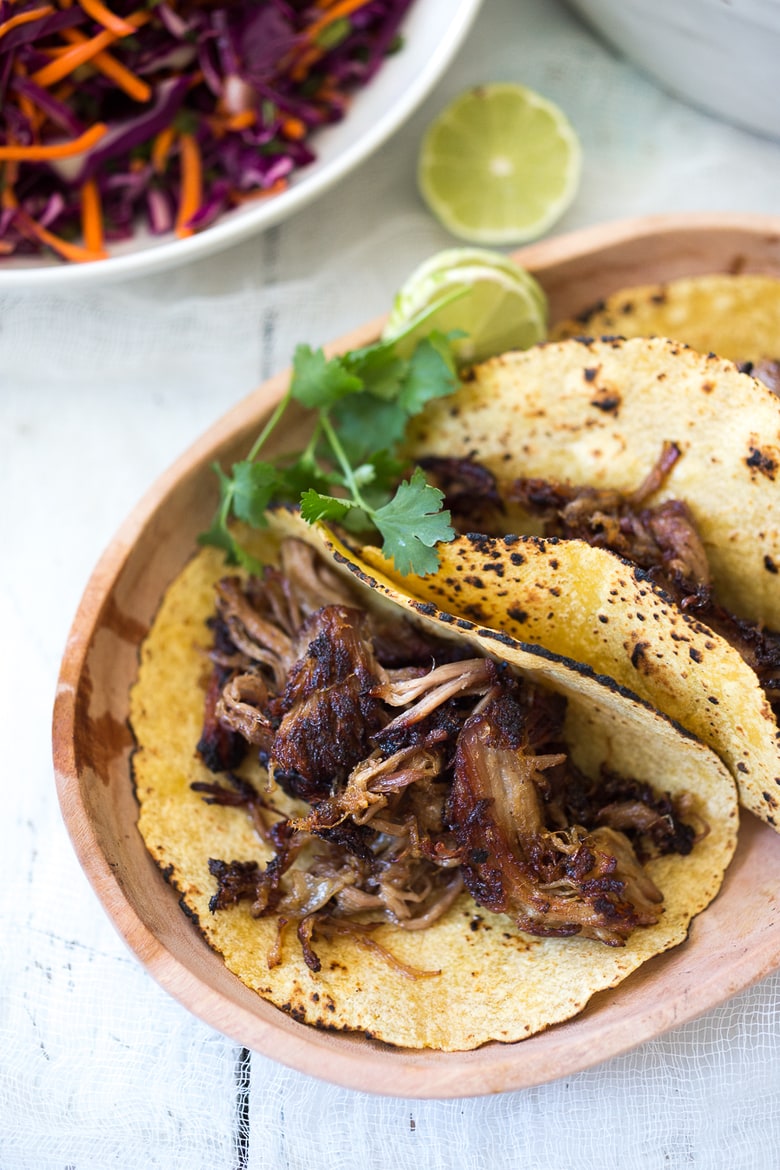 Delicious slow-roasted, Pulled Pork Tacos are rubbed with flavorful Five Spice seasoning and served with Asian Slaw and a Spicy Sriracha Mayo.  A flavorful Asian twist on pulled pork tacos! #pulledporktacos #5spice #tacos