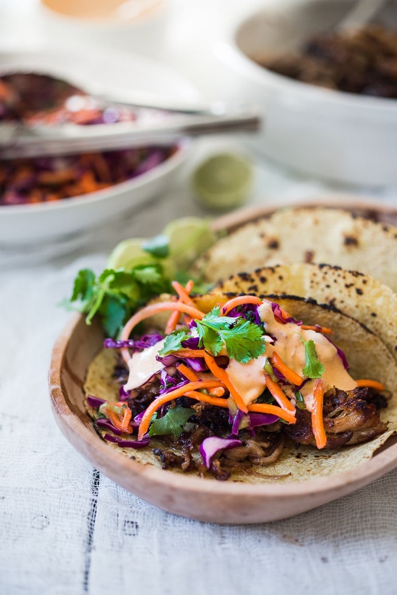 Delicious slow-roasted, Pulled Pork Tacos are rubbed with flavorful Five Spice seasoning and served with Asian Slaw and a Spicy Sriracha Mayo.  A flavorful Asian twist on pulled pork tacos! #pulledporktacos #5spice #tacos