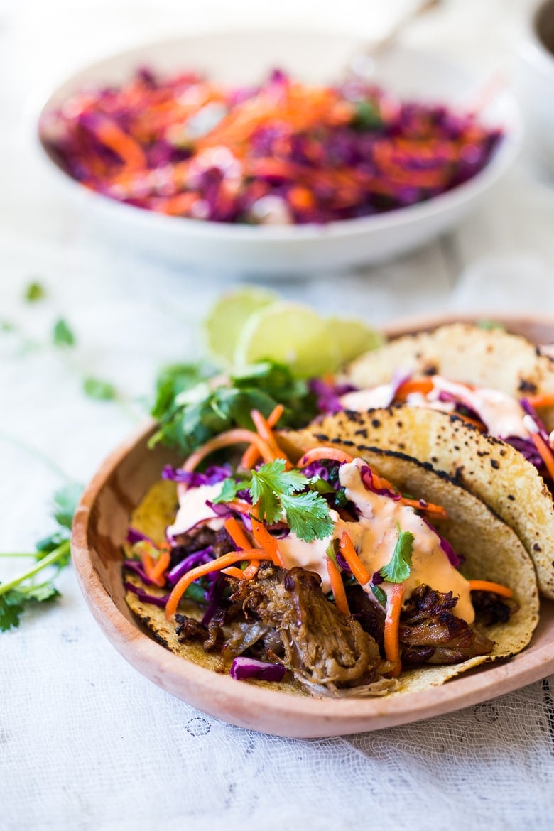 Delicious slow-roasted, Pulled Pork Tacos are rubbed with flavorful Five Spice seasoning and served with Asian Slaw and a Spicy Sriracha Mayo.  A flavorful Asian twist on pulled pork tacos! #pulledporktacos #5spice #tacos