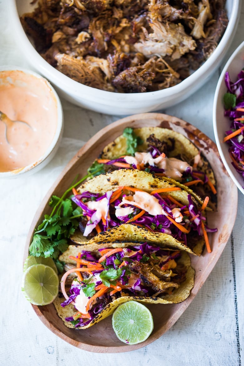 Delicious slow-roasted, Pulled Pork Tacos are rubbed with flavorful Five Spice seasoning and served with Asian Slaw and a Spicy Sriracha Mayo.  A flavorful Asian twist on pulled pork tacos! #pulledporktacos #5spice #tacos