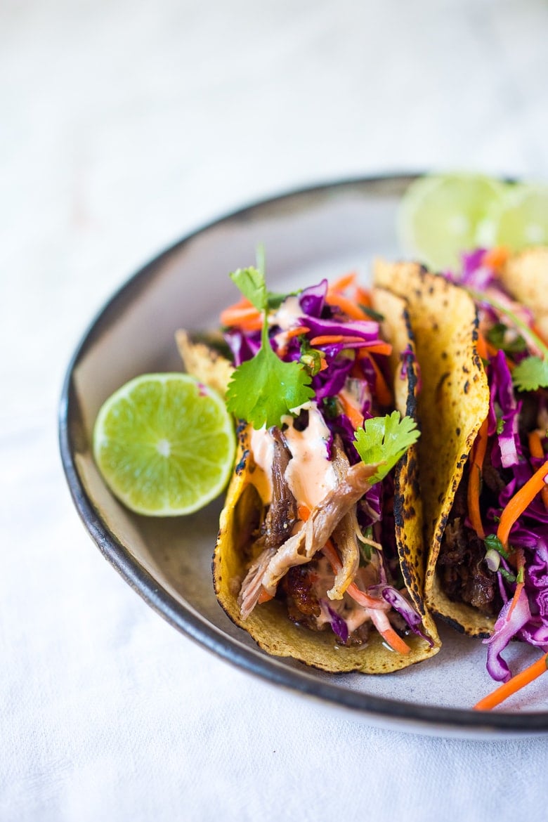 Delicious slow-roasted, Pulled Pork Tacos are rubbed with flavorful Five Spice seasoning and served with Asian Slaw and a Spicy Sriracha Mayo.  A flavorful Asian twist on pulled pork tacos! #pulledporktacos #5spice #tacos
