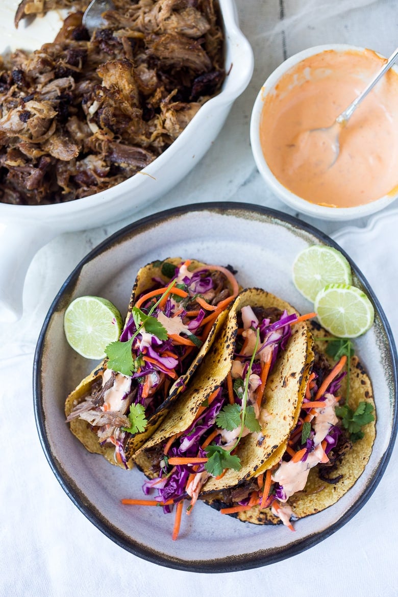 Delicious slow-roasted, Pulled Pork Tacos are rubbed with flavorful Five Spice seasoning and served with Asian Slaw and a Spicy Sriracha Mayo.  A flavorful Asian twist on pulled pork tacos! #pulledporktacos #5spice #tacos