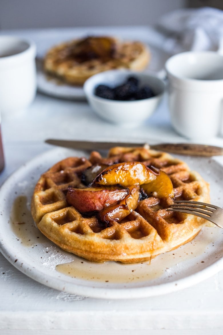 Crisp and light, Sourdough Waffles are delicious and SO simple to make using your extra starter. Top w/ Maple-glazed peaches or stone fruit.| www.feastingathome.com