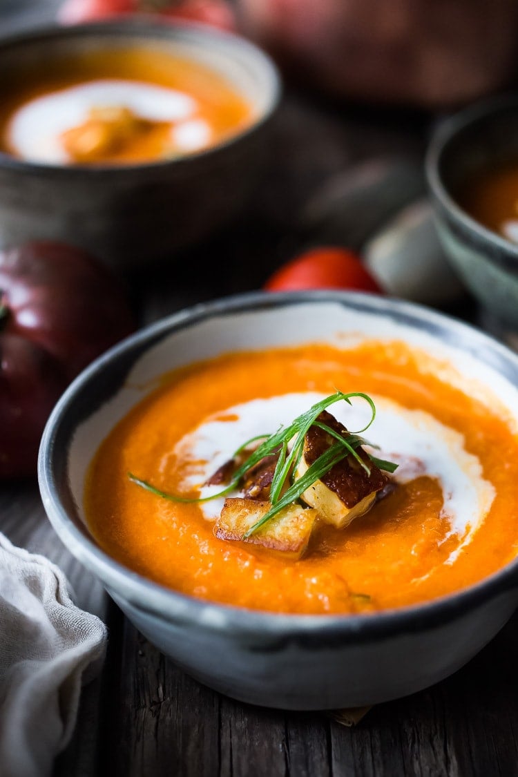 Roasted Tomato Soup with fresh roasted heirloom tomatoes, topped with crispy Haloumi Croutons. A healthy bowl of velvety goodness! | www.feastingathome.com | #tomatosoup #soup #vegetarian #haloumi #roastedtomatoes #roastedtomatosoup 