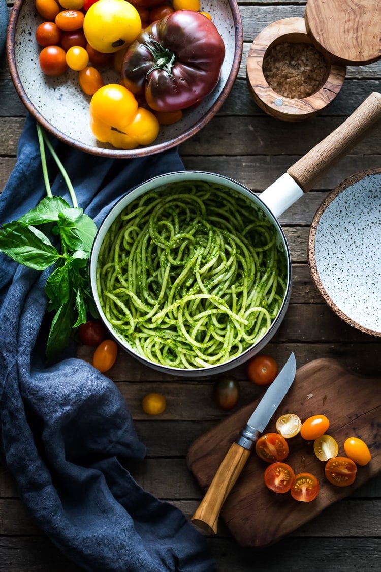 Bucatini Pasta with Arugula Pesto and Heirloom Tomatoes. A fast and flavorful weeknight dinner recipe. This Healthy pasta is Vegan! #bucatini #bucatinipasta #pastawithpesto #arugulapesto www.feastingathome.com 