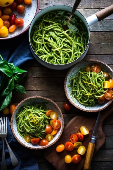 Bucatini Pasta with Arugula Pesto and Heirloom Tomatoes. A fast and flavorful weeknight dinner recipe. This Healthy pasta is Vegan! #bucatini #bucatinipasta #pastawithpesto #arugulapesto www.feastingathome.com