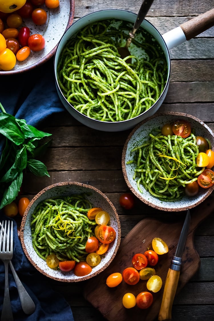 Bucatini Pasta with Arugula Pesto and Heirloom Tomatoes. A fast and flavorful weeknight dinner recipe. This Healthy pasta is Vegan! #bucatini #bucatinipasta #pastawithpesto #arugulapesto www.feastingathome.com 