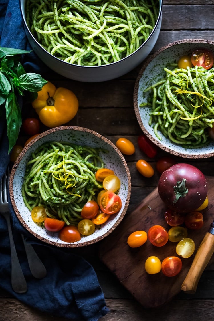 Best Vegetarian & Vegan Pasta Recipes: Bucatini Pasta with Arugula Pesto and Heirloom Tomatoes. A fast and flavorful weeknight dinner that can be made in 30 mins! This vegan pasta recipe is easy and healthy! #bucatini #bucatinipasta #veganpasta #healthypasta #vegetarianpasta #pastawithpesto #arugulapesto www.feastingathome.com