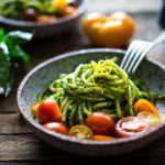 Bucatini Pasta with Arugula Pesto and Heirloom Tomatoes. A fast and flavorful weeknight dinner recipe. This Healthy pasta is Vegan! #bucatini #bucatinipasta #pastawithpesto #arugulapesto www.feastingathome.com