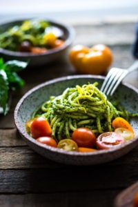 Bucatini Pasta with Arugula Pesto and Heirloom Tomatoes. A fast and flavorful weeknight dinner recipe. This Healthy pasta is Vegan! #bucatini #bucatinipasta #pastawithpesto #arugulapesto www.feastingathome.com