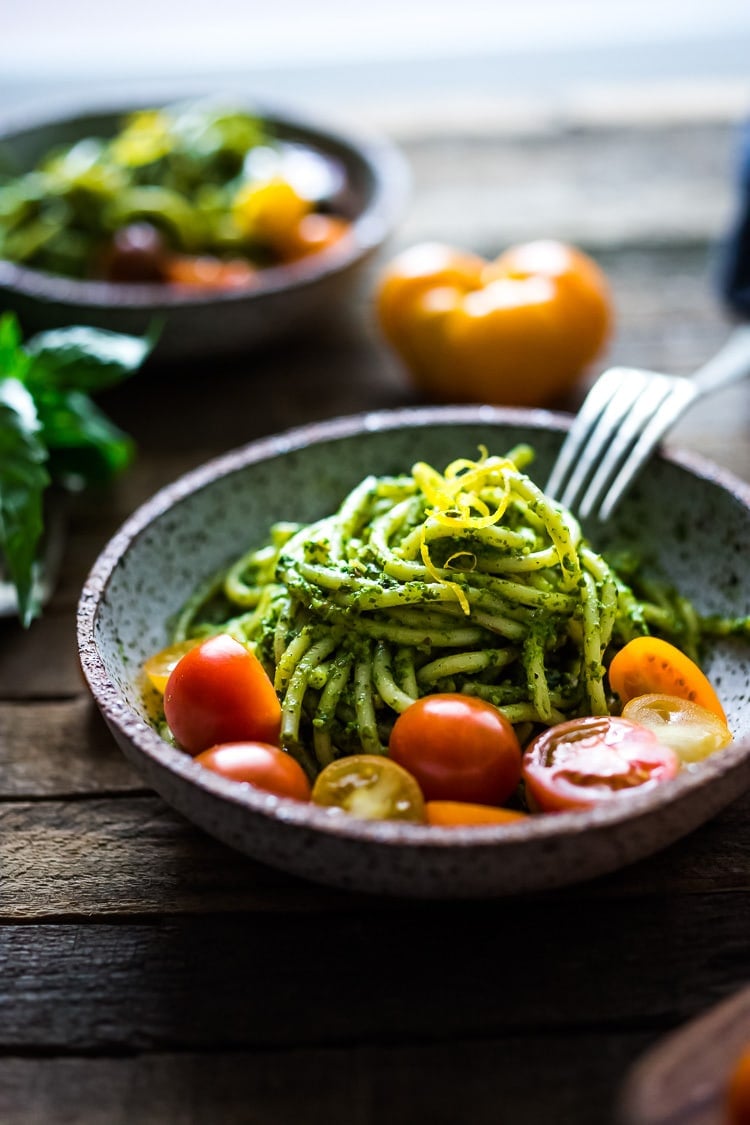 Bucatini Pasta with Arugula Pesto and Heirloom Tomatoes. A fast and flavorful weeknight dinner recipe. This Healthy pasta is Vegan! #bucatini #bucatinipasta #pastawithpesto #arugulapesto www.feastingathome.com 