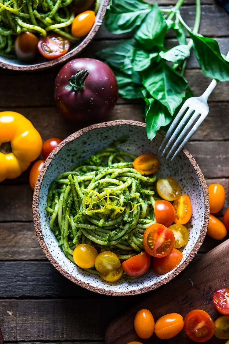 Bucatini Pasta with Arugula Pesto and Heirloom Tomatoes. A fast and flavorful weeknight dinner recipe. This Healthy pasta is Vegan! #bucatini #bucatinipasta #pastawithpesto #arugulapesto www.feastingathome.com 