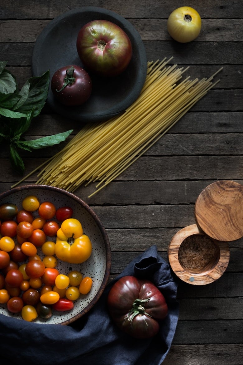 Bucatini Pasta with Arugula Pesto and Heirloom Tomatoes. A fast and flavorful weeknight dinner recipe. This Healthy pasta is Vegan! #bucatini #bucatinipasta #pastawithpesto #arugulapesto www.feastingathome.com 