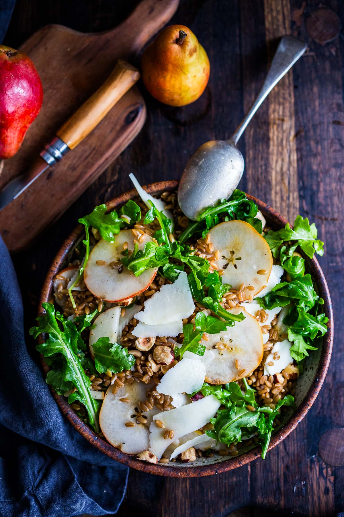 bowl of farro salad with sliced pear, shaved pecorino, toasted hazelnuts, and arugula. 