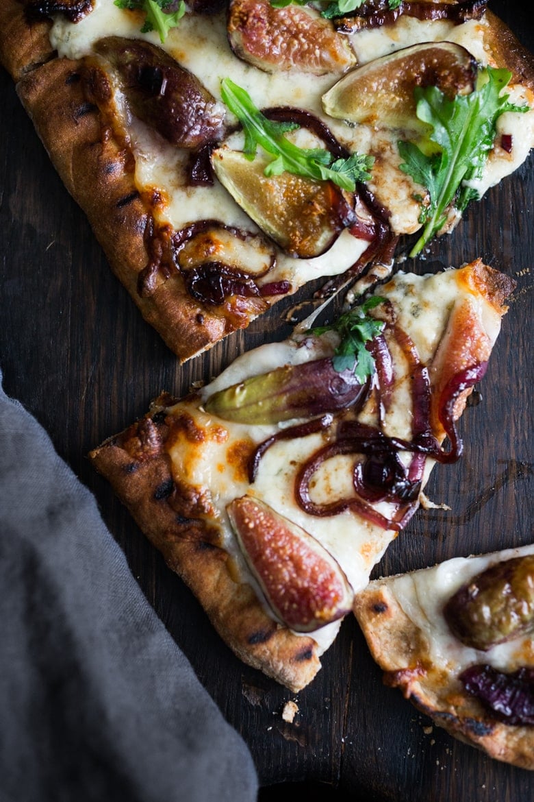 This delicious Fig Pizza with balsamic onions, creamy gorgonzola cheese, and fresh arugula is the perfect combination of flavors! Bake it or grill it, either way, you'll love this fall-inspired vegetarian pizza!