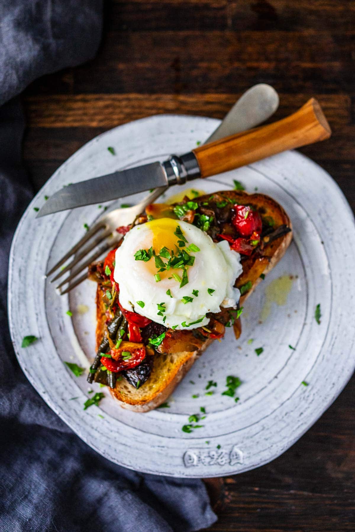 Ratatouille served over toast with egg for breakfast. 