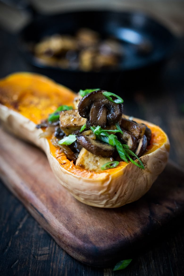 stuffed butternut squash with miso mushrooms topped with scallions.