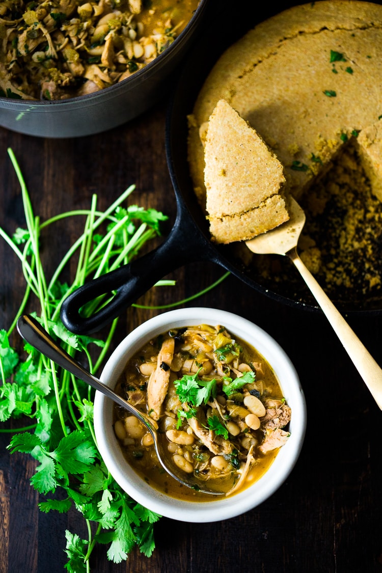 White Chicken Chili is made with with white beans, poblano chilies, cilantro, coriander and lime. Tangy, spicy, this one-pot meal is hearty and delicious! | www.feastingathome.com #whitechili #whitechickenchili #chili #chiliverde 