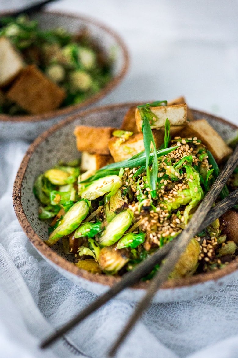 This Stir-fry Tofu, Brussels Sprouts & Mushroom Bowl with scallions and toasted sesame seeds can be made in under 20 minutes and is vegan! Tasty and easy, perfect for a quick healthy weeknight dinner. 