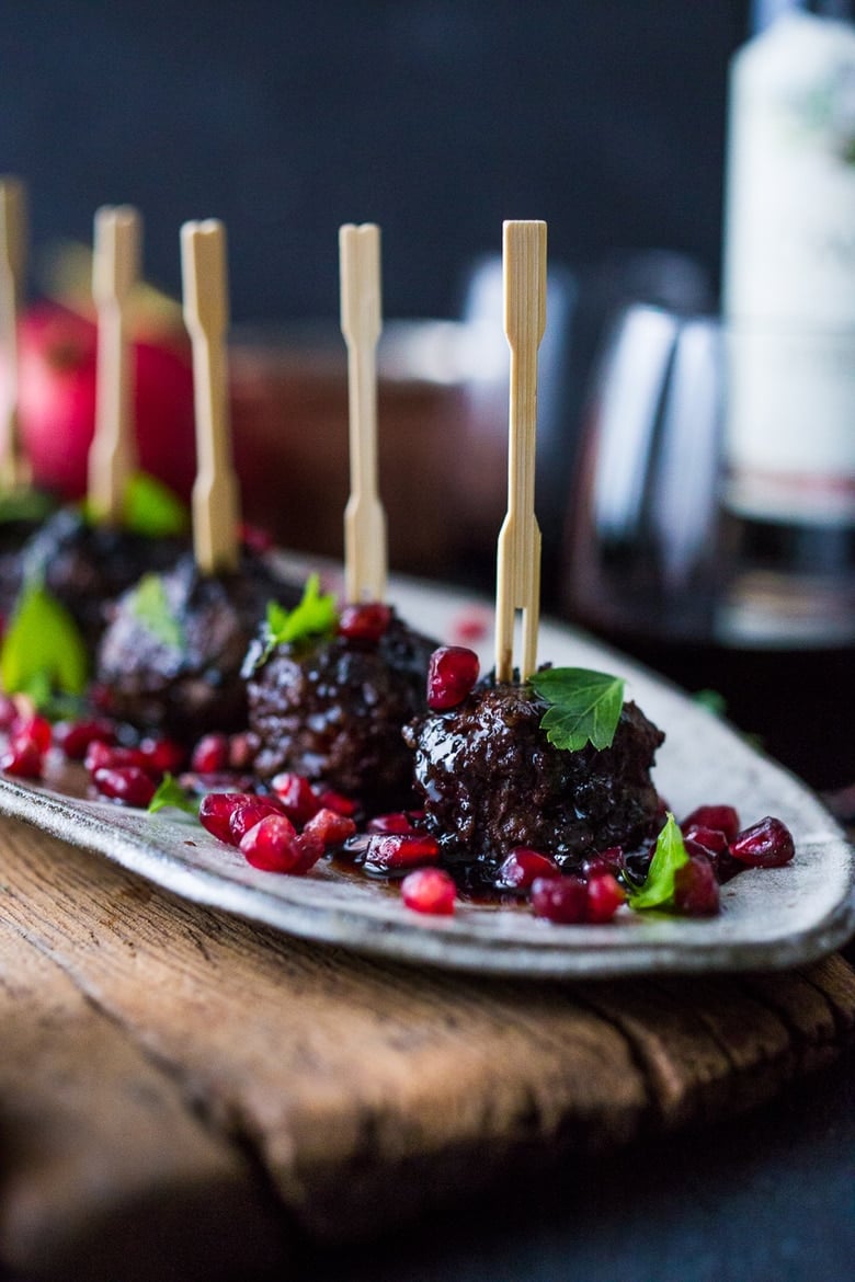 Moroccan Meatballs with Pomegranate Glaze- a festive holiday appetizer, or serve as a sumptious main dish with fluffy cous cous. | www.feastingathome.com