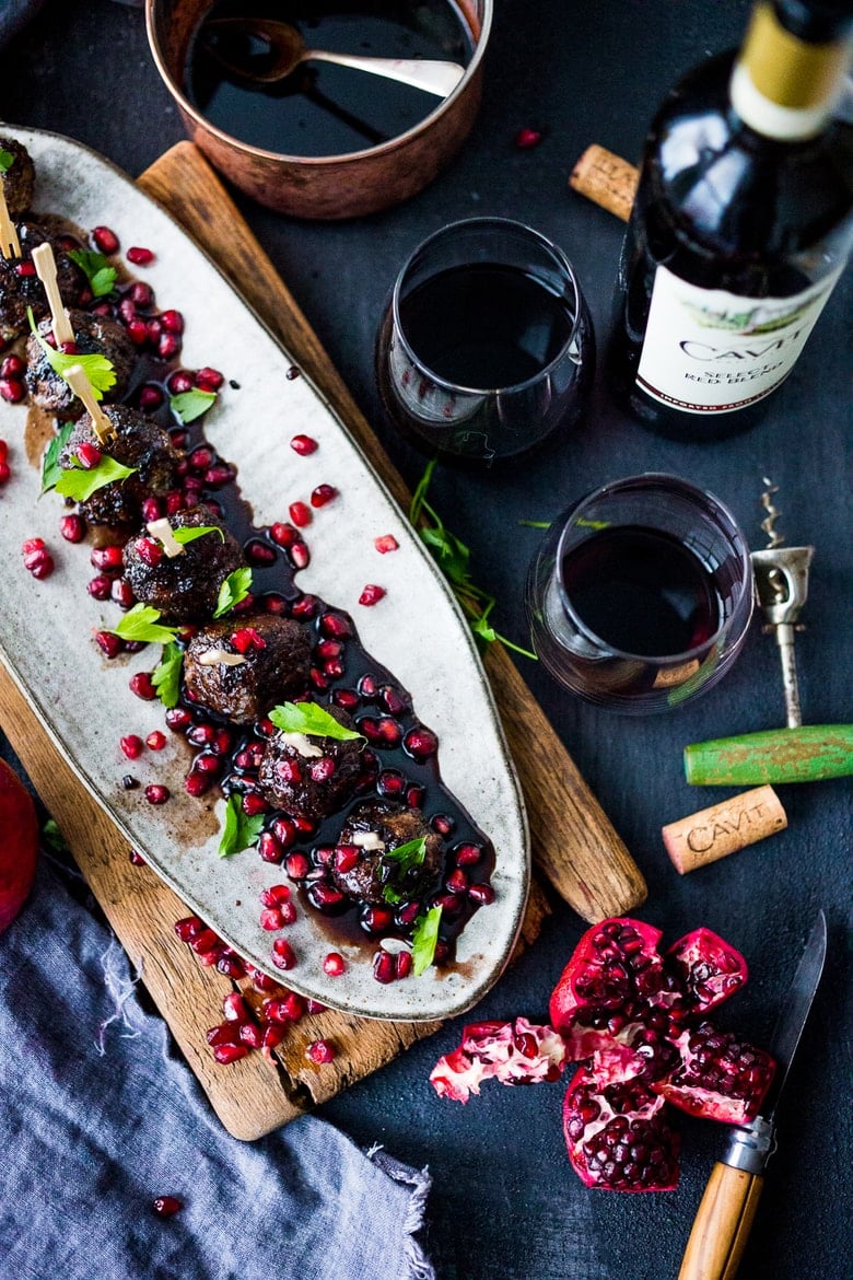 Moroccan Meatballs with Pomegranate Glaze- a festive holiday appetizer, or serve as a sumptious main dish with fluffy cous cous. | www.feastingathome.com