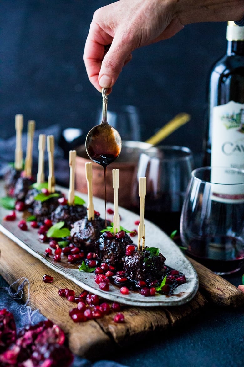 Moroccan Meatballs with Pomegranate Glaze- a festive holiday appetizer, or serve as a sumptious main dish with fluffy cous cous. | www.feastingathome.com