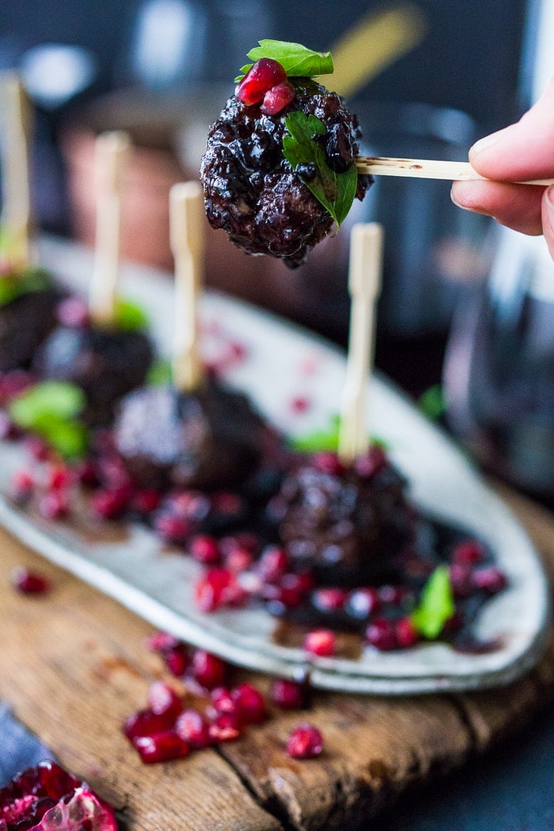 Moroccan Meatballs with Pomegranate Glaze- a festive holiday appetizer, or serve as a sumptious main dish with fluffy cous cous. | www.feastingathome.com