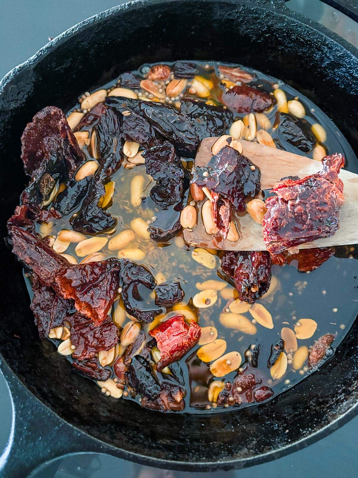 Adding the chiles to the hot oil in a skillet, and stirring. 