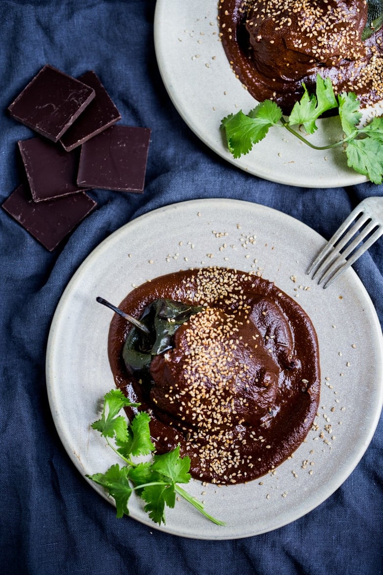 Stuffed Poblano Chili with black beans, quinoa, optional goat cheese- topped with a dark, complex and luscious Mole Negro Sauce. | www.feastingathome.com