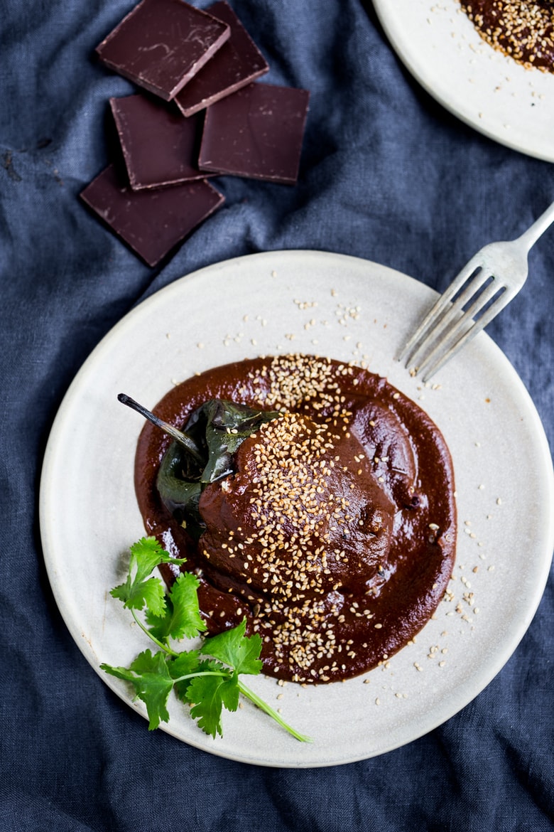 Quinoa Stuffed Poblano Chili with black beans, quinoa, goat cheese- topped with a dark complex Mole Negro Sauce. | www.feastingathome.com