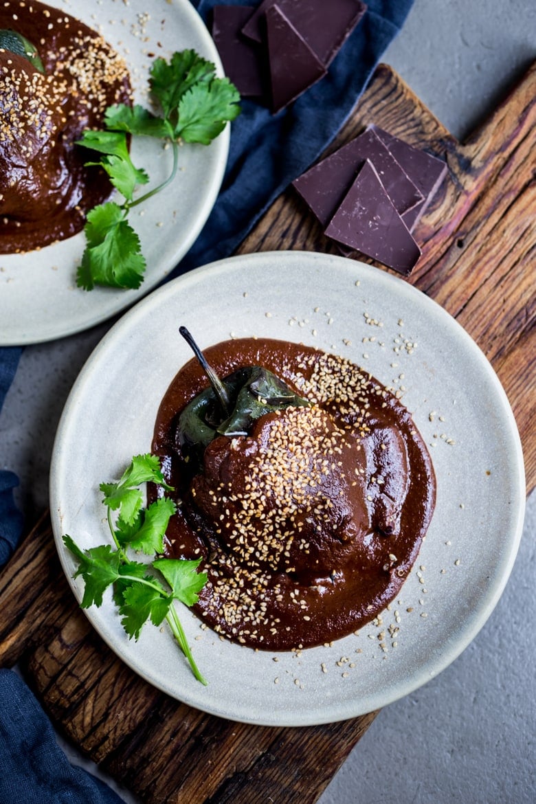 Stuffed Poblano Chili with black beans, quinoa, optional goat cheese- topped with a dark, complex and luscious Mole Negro Sauce. | www.feastingathome.com