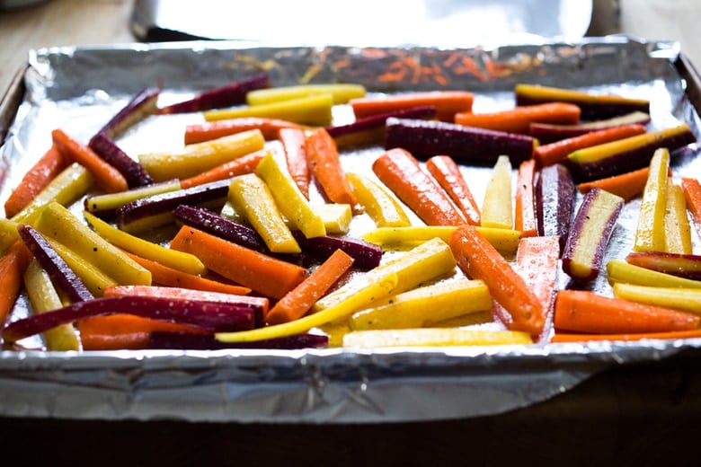 A simple tasty recipe for Roasted Moroccan Carrots- with cumin cinnamon and orange. Serve as a side or over seasoned lentils for a hearty vegetarian meal. | www.feastingathome.com