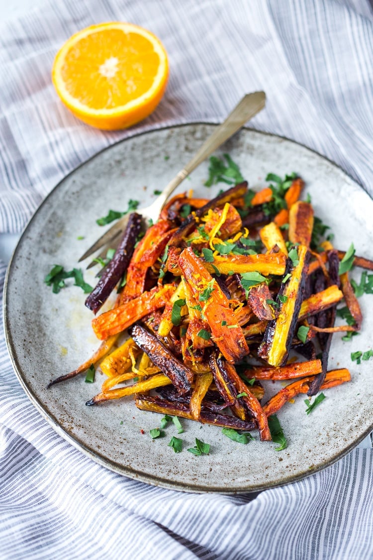 Sweet and Spicy Roasted Moroccan Carrots- with cumin, cinnamon and orange. A Delicious vegan side dish or serve over seasoned lentils for a hearty vegetarian meal. | www.feastingathome.com #carrots #roastedcarrots #moroccancarrots #vegan #vegansalad #cleaneating 