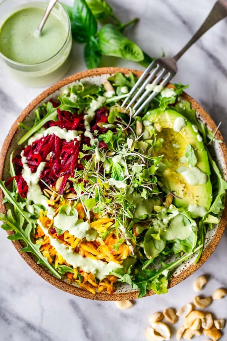 A delicious vegan Raw Beet Salad with Avocado, tender greens, sprouts, toasted pumpkin seeds, pickled shallots, tossed in a flavorful, creamy, vegan Cashew Basil Dressing.