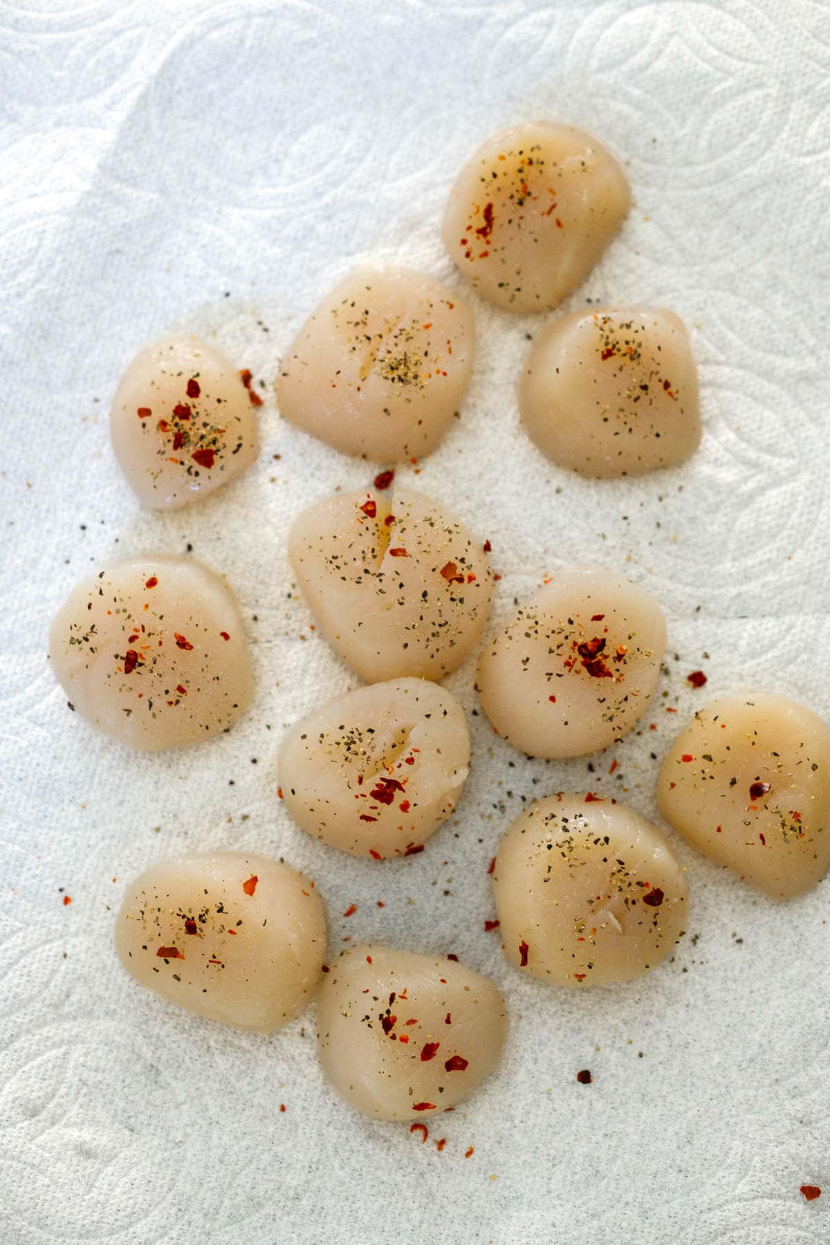 dry scallops on paper towel, seasoned with salt, pepper, and chili flakes.