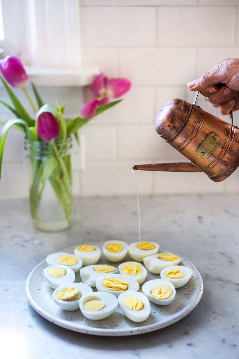 Simple Boiled Eggs with olive oil, herbs and pickled shallots- a fast and tasty way to use up all your Easter Eggs or feed a crowd. | www.feastingathome.com