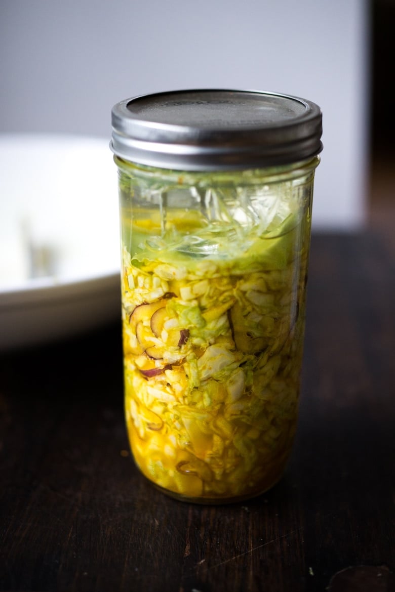 How to make Turmeric Sauerkraut- a small-batch recipe that can be put together in 10 minutes, and sits on the counter for 3-5 days. | #kraut #fermented #sauerkraut www.feastingathome.com