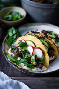 Greek lamb Tacos with Minted Yogurt Sauce, cucumber, radish, feta and an herb-caper drizzle- a feast for the senses! | www.feastingathome.com