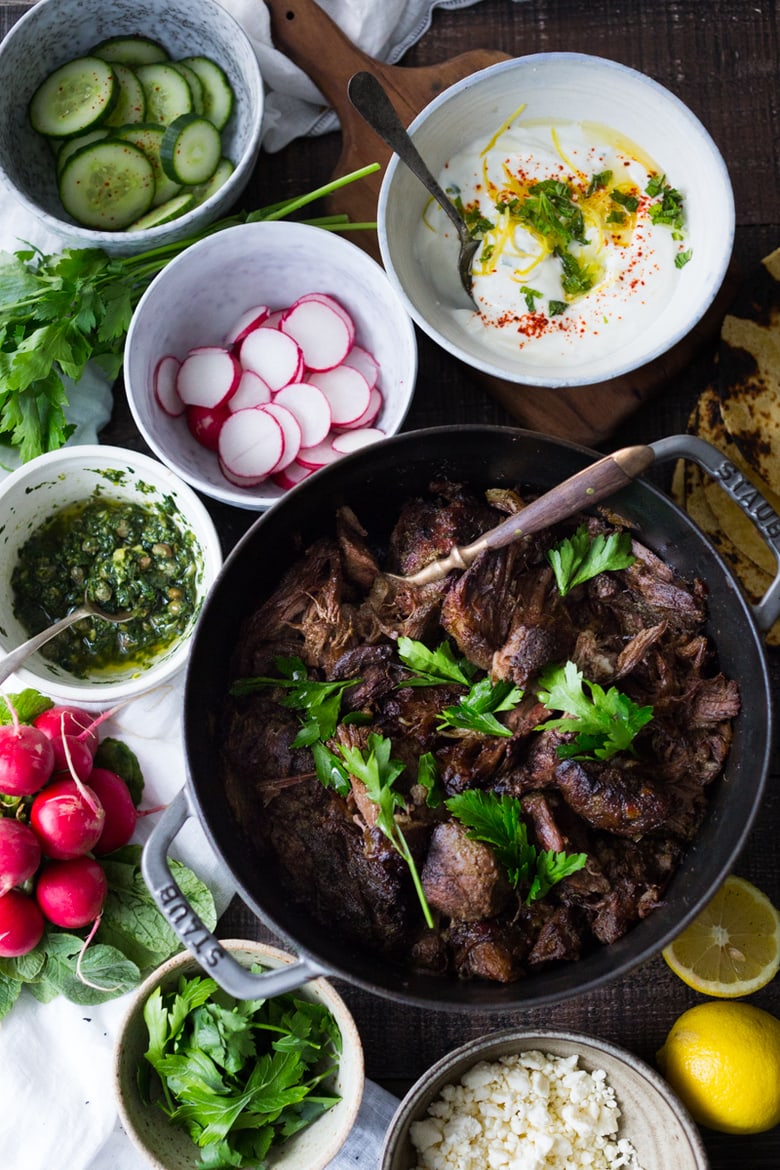 Greek Lamb Tacos with Tzatziki Sauce, cucumber and radishes. A Made with tender, falling off the bone, slow-roasted Lamb shoulder. Delicious flavors! #lamb #lambtacos #lambshoulder #slowroasted #braisedlamb www.feastingathome.com