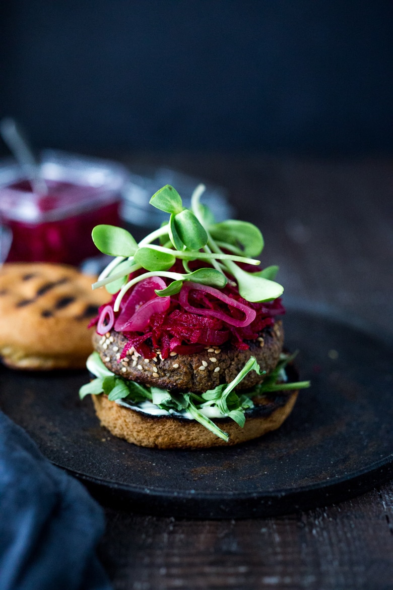 Sprouted Lentil Burgers- made with walnuts and brown rice, these grillable, vegan and gluten-free adaptable. Super healthy and delicious, packed with living nutrients! Topped with picked beets. | www.feastingathome.com