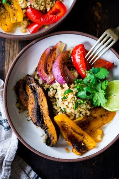 Vegan Fajitas with Cauliflower Rice are loaded up with healthy veggies that are lathered in flavorful Mexican Marinade and served over cauliflower "rice". The best thing? You can bake it all on a sheet pan with just 15 minutes of hands-on time. Keep it vegan or add chicken!