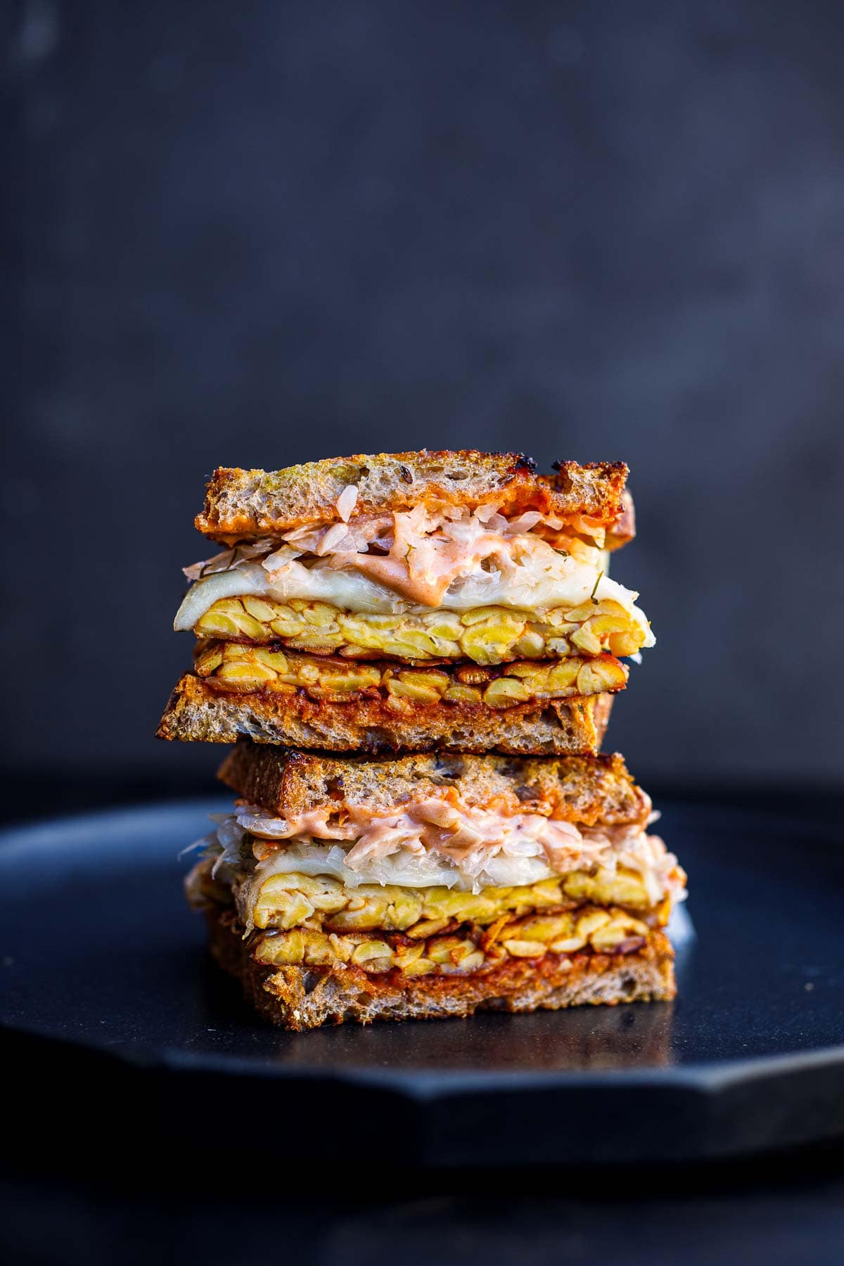 tempeh reuben sandwich, cut in half and stacked up high. 