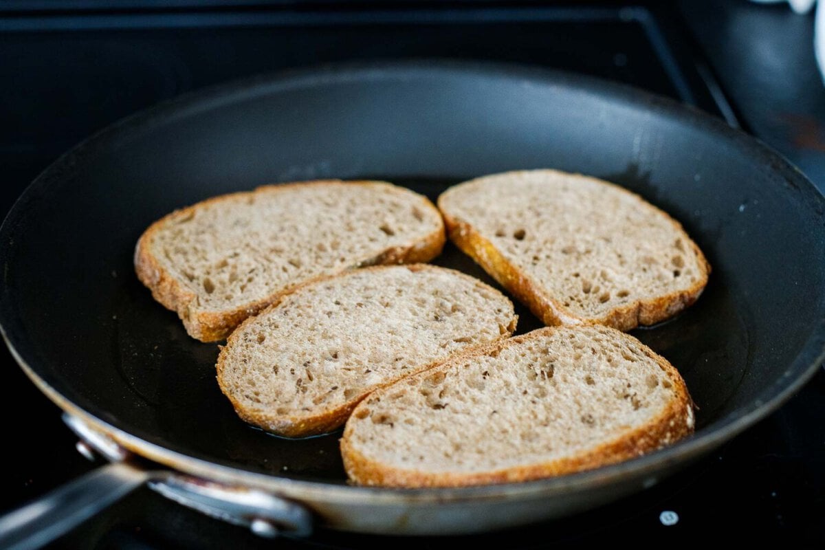 toasting rye bread in a skillet.