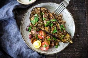 Zataar Roasted Eggplant with fresh tomatoes, tahini or yogurt sauce and cooked grain. A healthy vegan gluten-free meal.