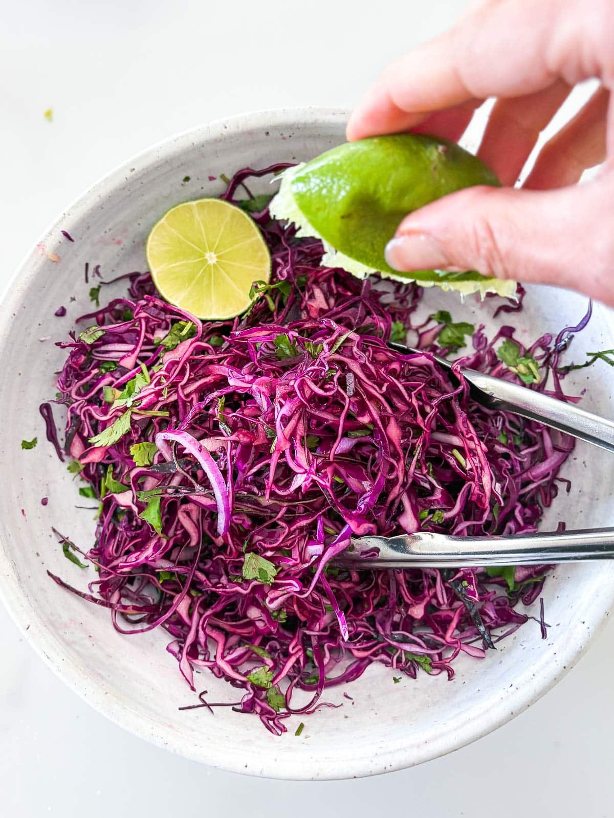 Adding lime juice to the purple cabbage slaw.