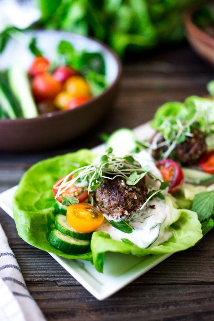 grilled lamb kofta lettuce wraps with tzatziki, cherry tomatoes, cucumbers, and microgreens.