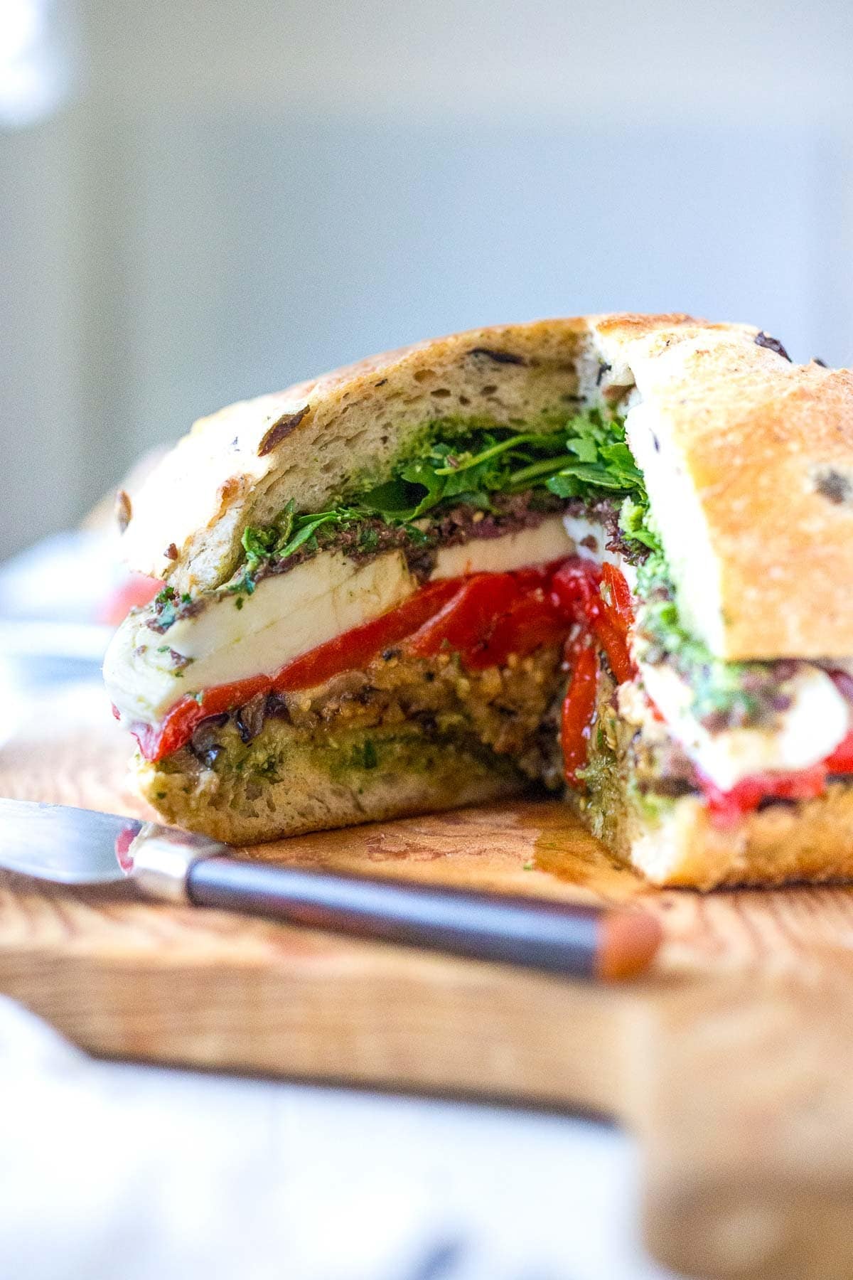How to make a vegetarian Muffuletta Sandwich with grilled vegetables, pesto, mozzarella cheese, and Olive Tapenade. Great for picnics or summer gatherings.