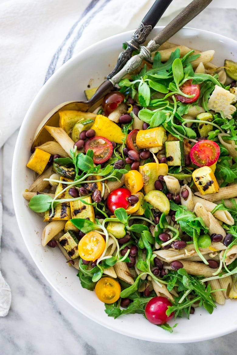 Farmers Market Pasta Salad with corn, cherry tomatoes and black beans. Make this summer pasta salad recipe gluten-free with optional grain-free pasta and keep it vegan or add feta. Very adaptable! Serve it warm for dinner or chilled for midweek lunches. | #zucchini #zucchinipasta #cornpasta #farmersmarket #summerpasta #pastasalad #glutenfree #vegan www.feastingathome.com #farmersmarketpasta