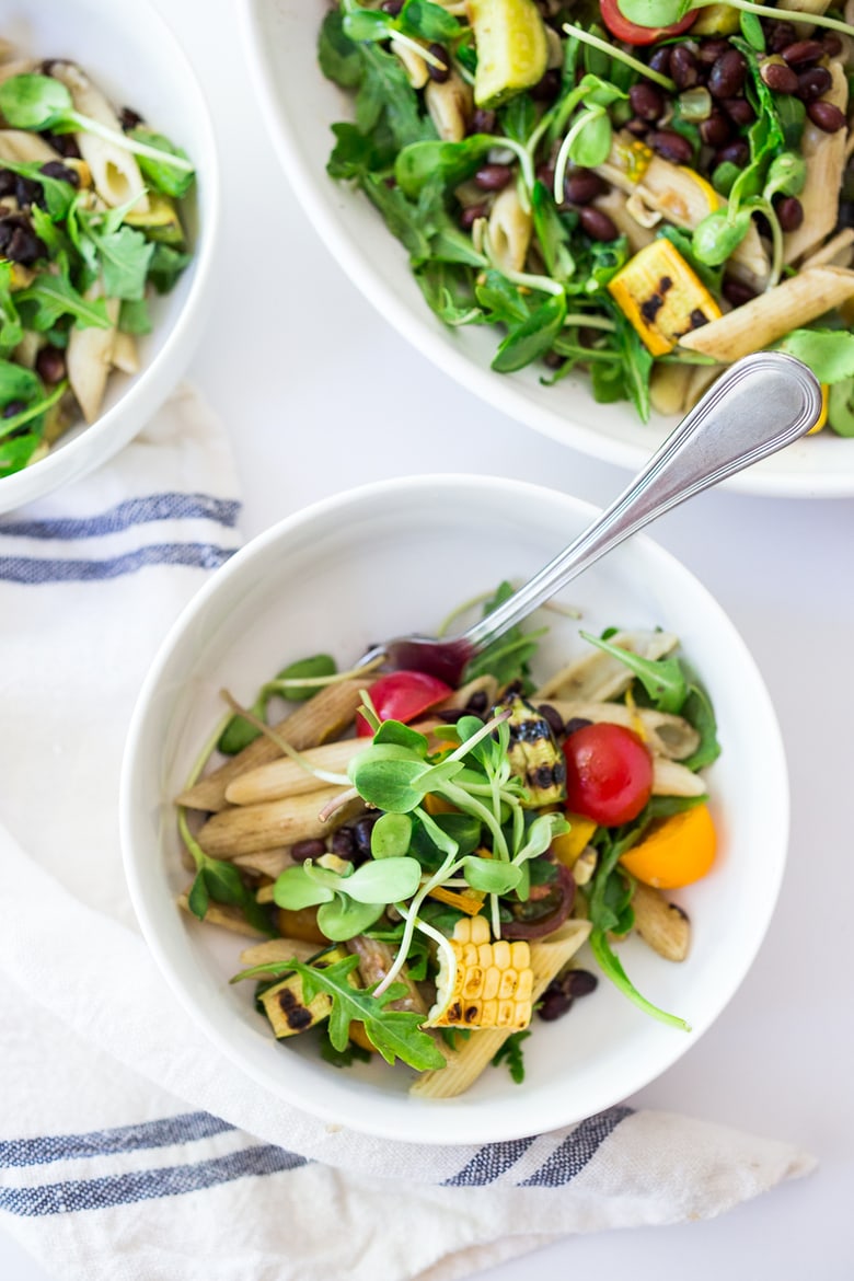 Farmers Market Pasta Salad with corn, cherry tomatoes and black beans. Make this summer pasta salad recipe gluten-free with optional grain-free pasta and keep it vegan or add feta. Very adaptable! Serve it warm for dinner or chilled for midweek lunches. | #zucchini #zucchinipasta #cornpasta #farmersmarket #summerpasta #pastasalad #glutenfree #vegan www.feastingathome.com #farmersmarketpasta